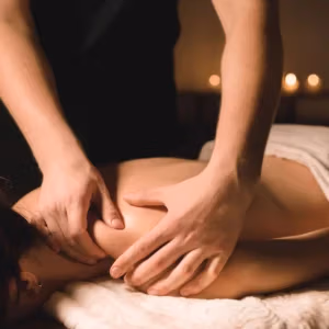 Close Up Male Manual Worker Doing Spa Massage To A Young Girl In A Dark Room.